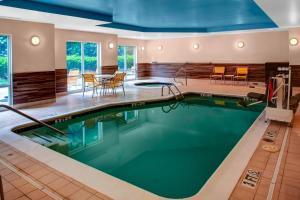 a pool in a hotel with a table and chairs at Fairfield Inn and Suites by Marriott Emporia I-95 in Emporia