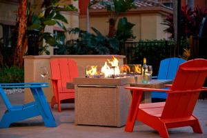 Residence Inn by Marriott Naples في نيبلس: مجموعة من الكراسي وطاولة مع حفرة نار