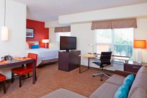Residence Inn by Marriott Naples في نيبلس: غرفة في الفندق بها سرير وأريكة ومكتب