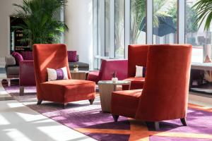a lobby with two orange chairs and a table at Courtyard by Marriott Los Angeles L.A. LIVE in Los Angeles
