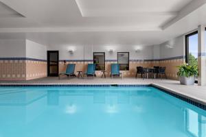 a swimming pool with chairs and a table in a hotel at TownPlaces Suite Denver Airport at Gateway Park in Aurora