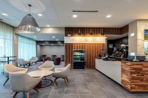 a lobby with tables and chairs and a bar at Courtyard by Marriott Savannah Airport in Savannah