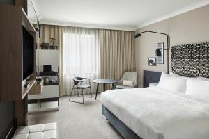 ロンドンにあるロンドン マリオット メイダ ヴェールのベッドとテーブルが備わるホテルルームです。