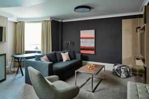 a living room with a blue couch and chairs at London Marriott Maida Vale in London