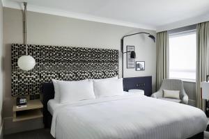 a hotel room with a bed and a chair at London Marriott Maida Vale in London