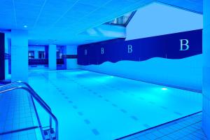 - une piscine avec des lumières bleues dans un bâtiment dans l'établissement London Marriott Maida Vale, à Londres