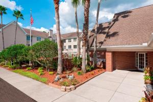 a house with palm trees and a flag at Residence Inn Tampa Sabal Park/Brandon in Tampa