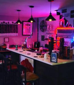un bar con iluminación rosa y barra de bar en Atlantic Coast Lodge en Spanish Point