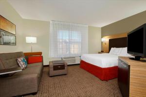 Habitación de hotel con cama y sofá en TownePlace Suites Fort Worth Southwest TCU Area, en Fort Worth