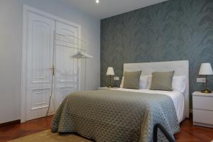 a bedroom with a white bed and a green wall at Céntrico y acogedor piso con garaje in A Coruña