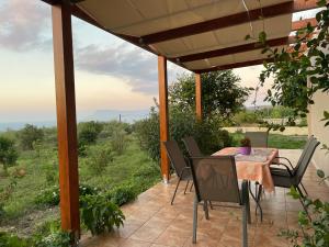 einen Tisch und Stühle auf einer Terrasse mit Aussicht in der Unterkunft Chrissi's house with garden and sea view in Kissamos