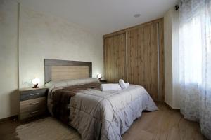 een slaapkamer met een groot bed en een groot raam bij Apartamento turístico la Vera in Aldeanueva de la Vera