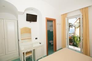 La salle de bains est pourvue d'un lavabo, de toilettes et d'un miroir. dans l'établissement Hotel Villa Sirena - Thermae & SPA, à Ischia