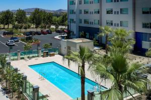 an overhead view of a pool with palm trees and a building at Element Ontario Rancho Cucamonga in Ontario