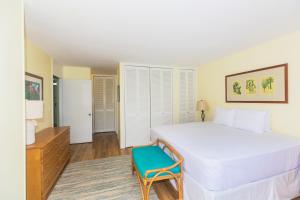 una camera con un grande letto bianco e una sedia blu di Ilikai Marina 899 City View 1BR a Honolulu
