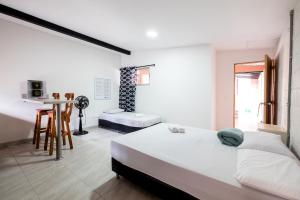 a bedroom with a bed and a table and a chair at Medellin Backpacker Hostel in Medellín