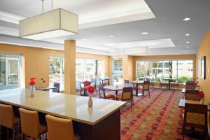 a dining room with tables and chairs and windows at TownePlace Suites by Marriott Mississauga-Airport Corporate Centre in Mississauga