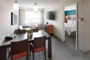 a hotel room with a bed and a dining room at TownePlace Suites by Marriott Mississauga-Airport Corporate Centre in Mississauga