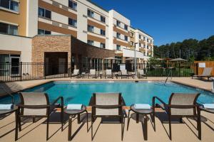 a swimming pool with chairs and a table in front of a building at Courtyard by Marriott Ruston in Ruston
