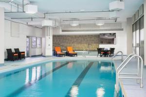 a swimming pool with orange chairs and a table at Delta Hotels by Marriott St. John's Conference Centre in St. John's