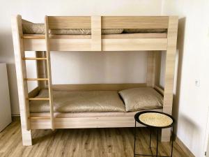 a wooden bunk bed in a room with a table at Apartmán 551 in Litomyšl