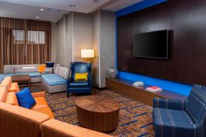 a living room with a couch and a flat screen tv at Courtyard by Marriott Bismarck North in Bismarck