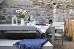 a table with flowers and wine bottles on it at No1 The Cleave in Kingsand