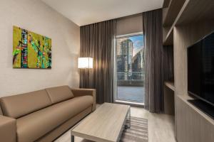 a living room with a couch and a large window at AC Hotel by Marriott Charlotte City Center in Charlotte