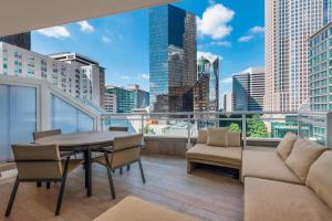 balcón con mesa, sillas y vistas a la ciudad en AC Hotel by Marriott Charlotte City Center en Charlotte