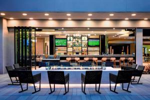 un restaurante con mesas y sillas y un bar en Torrance Marriott Redondo Beach, en Torrance