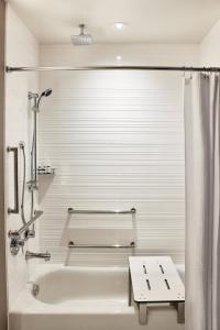 a white bathroom with a tub and a shower at AC Hotel by Marriott Missoula Downtown in Missoula