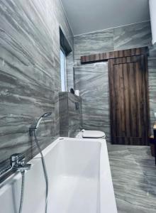 ein Bad mit einer Badewanne und einem WC in der Unterkunft The Hazel penthouse with private jacuzzi in Birkirkara