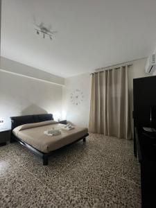 ein Schlafzimmer mit einem Bett und einer Uhr an der Wand in der Unterkunft Scicocco Sweet Home in Bagnoli del Trigno