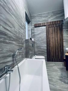 uma casa de banho com banheira e WC em The Hazel penthouse with private jacuzzi em Birkirkara