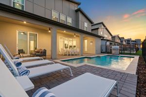 ein Haus mit einem Pool und einigen Stühlen in der Unterkunft Villatel at Harbor Island Beach Club in Melbourne Beach