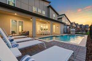 a house with a swimming pool and some chairs at Villatel at Harbor Island Beach Club in Melbourne Beach