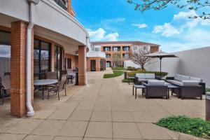 a patio with tables and chairs and a building at Courtyard by Marriott West Orange in West Orange