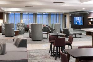 西奧蘭治的住宿－西奧蘭治萬怡酒店，大堂设有桌椅和平面电视。