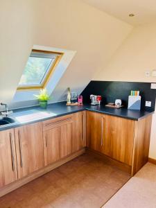 an attic kitchen with a sink and a window at 1 Loch Ness Heights in Inverness