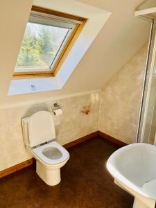 a bathroom with a white toilet and a sink at 1 Loch Ness Heights in Inverness