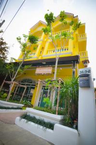 ein gelbes Gebäude mit einem Schild davor in der Unterkunft Norn-Nanta House in Chiang Mai