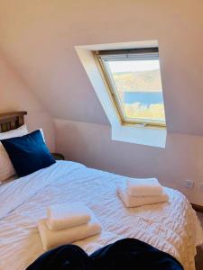 a bedroom with a bed with two towels on it at 1 Loch Ness Heights in Inverness