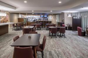 西奧蘭治的住宿－西奧蘭治萬怡酒店，一间带桌椅的餐厅和一间酒吧