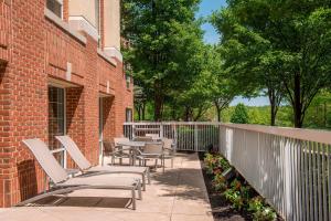 a patio with chairs and tables on a brick building at Springhill Suites by Marriott State College in State College