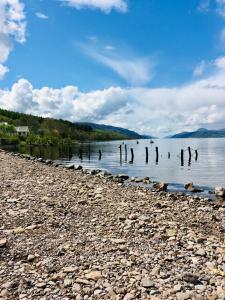 a beach with a group of posts in the water at 1 Loch Ness Heights in Inverness