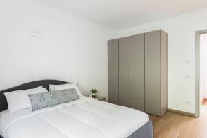 um quarto com uma cama branca e um armário em Casa Divina - Cadenabbia em Griante Cadenabbia