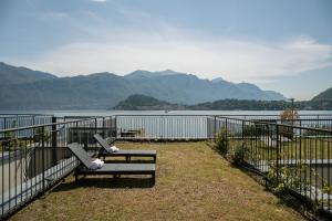 a bench sitting next to a fence next to a body of water at Casa Divina - Cadenabbia in Griante Cadenabbia