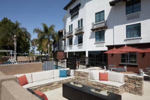 a patio with two couches and an umbrella in front of a building at Fairfield Inn & Suites By Marriott Camarillo in Camarillo