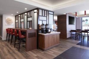 a kitchen with a bar with red chairs in a room at Fairfield Inn & Suites By Marriott Camarillo in Camarillo