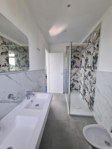 a white bathroom with a sink and a shower at Casamediterranea in Sperlonga